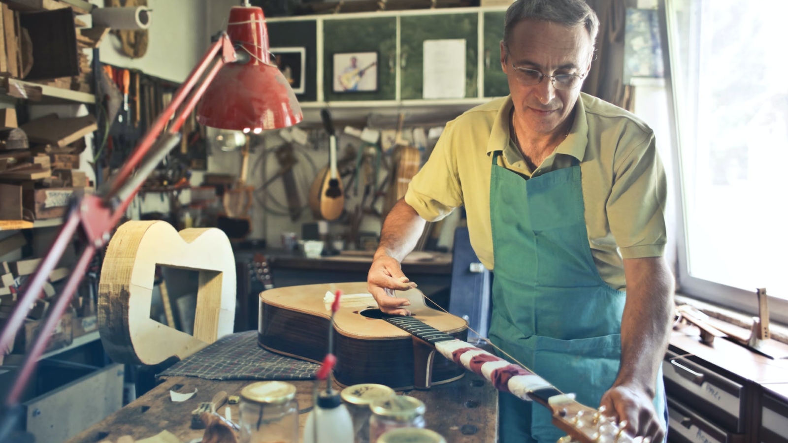 photo of man making an acoustic guitar